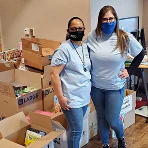 Pictured are SLFCU employees Kimberley Craft and Dolores Cotinola collecting children’s books during our drive-thru book drop-off on April 17.